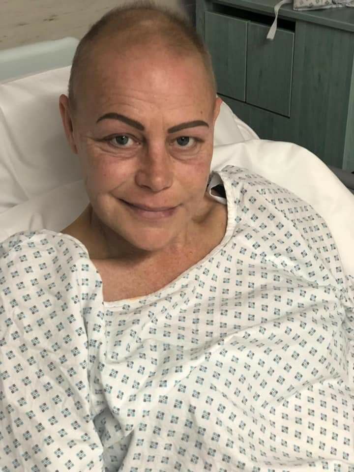 A cancer patient resting in a hospital bed, looking at the camera